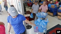 Customers purchase groceries at a local supermarket as they prepare for Hurricane Irma, Sept. 5, 2017, in Hialeah, Fla.