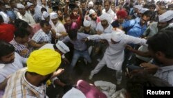 Protesters gather around a farmer who hung himself from a tree during a rally organized by AAP, in New Delhi, India, April 22, 2015. The farmer hanged himself, in what appeared to be a desperate protest against the hardship felt by many people scratching a living in rural India. 