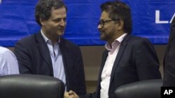 Ivan Marquez, chief negotiator of the Revolutionary Armed Forces of Colombia, right, and Sergio Jaramillo, Colombia's government peace commissioner, shake hands in Havana, Cuba, after announcing a request for a U.N. observer mission, Jan. 19, 2016.