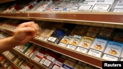 Packs of cigarettes are lined up on a shelf in a shop in Paris, Aug. 6, 2007. Tobacco companies were ordered to include new statements on cigarette packages by November 2018.