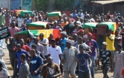 FILE - People carry coffins during the funeral after street protests and unrest that resulted in nine deaths in Conakry, Guinea, Nov. 4, 2019.