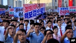 Tens of thousands of North Koreans rally at Kim Il Sung Square carrying placards and propaganda slogans as a show of support for their rejection of the United Nations' latest round of sanctions, in Pyongyang, North Korea, Aug. 9, 2017.