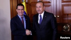 Menlu Venezuela Jorge Arreaza bersama Menlu Turki Mevlut Cavusoglu (kanan) di Ankara, Turki, 1 April 2019.