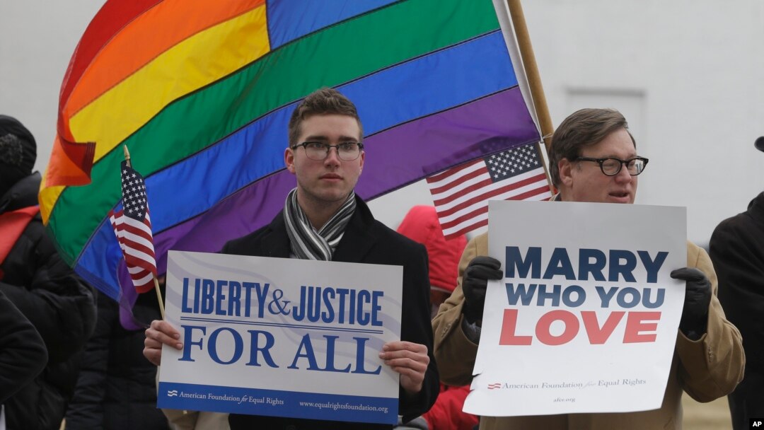 Spencer Geiger dari Virginia Beach (kiri) dan Carl Johanson dari Norfolk membawa kertas bertuliskan pesan dalam aksi demo di luar Pengadilan Norfolk, Virginia, 14 Februari 2014.