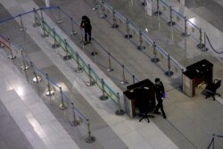 Petugas bea cukai yang memakai masker pelindung bersiap untuk memeriksa penumpang di terminal kedatangan internasional Bandara Internasional Soekarno-Hatta, di tengah wabah Covid-19 di Tangerang, 12 Maret 2020. (Foto: REUTERS/Willy Kurniawan)