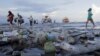 Tourists and local residents disembark a boat coming from nearby Nusa Penida island as plastic trash pollutes the beach in Sanur, Denpasar, Bali, Indonesia April 10, 2018.