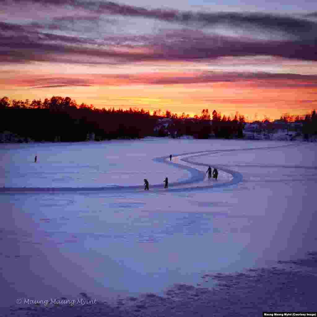 People skate on a frozen lake at sunset in Asker, Norway.