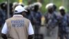 Un journaliste face aux forces de sécurité empêchant une foule de plusieurs centaines de journalistes et de membres du public de manifester devant le Palais des Congrès de Lomé, le 19 février 2013.