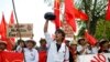 A student carries a monk's alms bowl turned upside down over his head, a Burmese symbol of protest, during a rally against education law in central Yangon, Nov. 17, 2014.