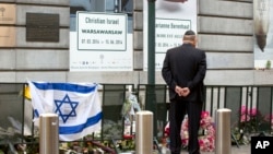 FILE - A man pays respects prior to a service for victims of a shooting — alleged to have been carried out in May by French-Algerian Mehdi Nemmouche — at the Jewish Museum in Brussels, June 2, 2014.