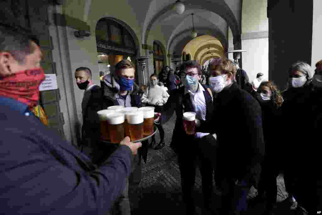 People line up for a beer at a restaurant terrace in Prague, Czech Republic.