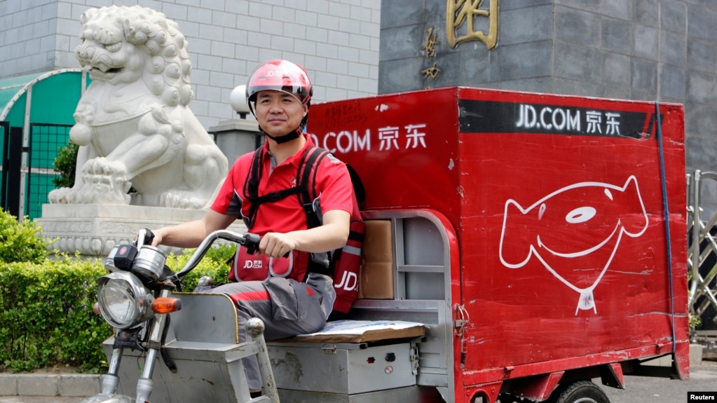 中国电子商务公司京东的首席执行官兼创始人刘强东2014年6月16日在北京开电动三轮车为客户送货，这是为了纪念公司成立日。(photo:VOA)