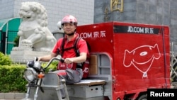 中国电子商务公司京东的首席执行官兼创始人刘强东2014年6月16日在北京开电动三轮车为客户送货，这是为了纪念公司成立日。