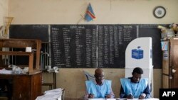 Officials from the Independent National Electoral Commission (CENI) count votes in a polling station at the Imara College in Lubumbashi on December 21, 2023.