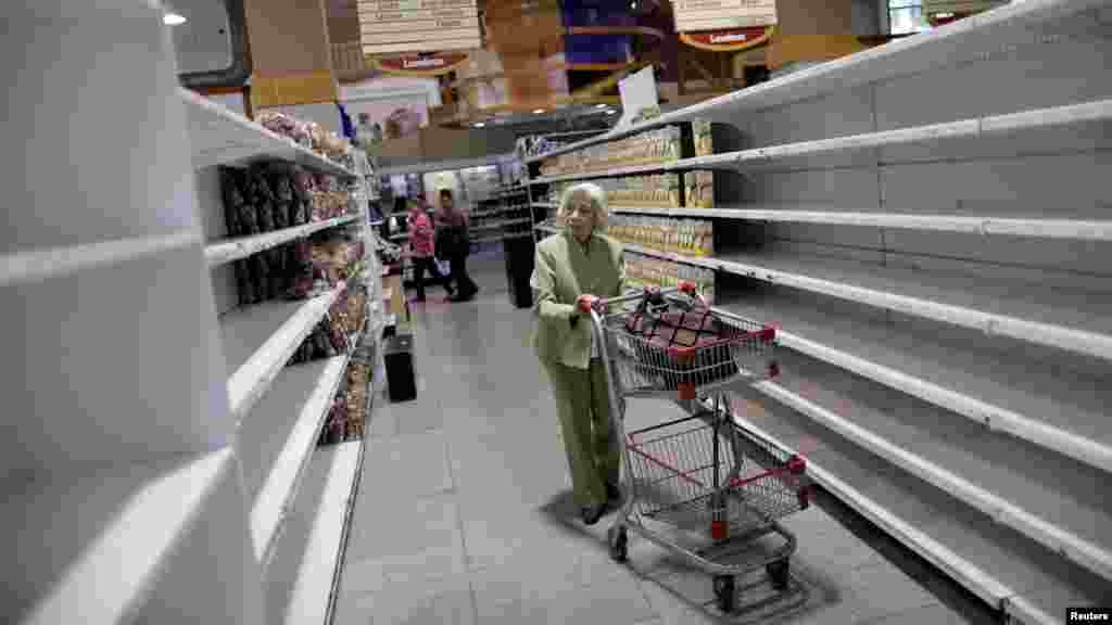 Seorang perempuan lansia berbelanja makanan dan barang kebutuhan pokok yang makin langka di sebuah supermarket di Caracas, Venezuela.