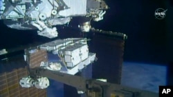 تصویری از یک ویدیوی ناسا کریستینا کاچ و اندرو مورگان را بیرون از ایستگاه فضایی بین المللی در حال کار کردن نشان می دهد - ۶ اکتبر ۲۰۱۹