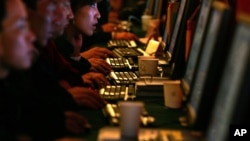 Chinese are seen working on computer work stations. Called 'bo ke' in Chinese, blogs are hugely popular, especially among the young, despite strict rules on content enforced by the government.