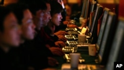 FILE - Chinese Web users are seen at computer workstations.
