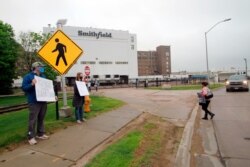 FILE - Residents cheer Smithfield meat plant workers as they begin their shift in Sioux Falls, S.D., May 20, 2020. Federal regulators said Sept. 10, 2020, they had cited Smithfield for failing to protect employees from coronavirus exposure.