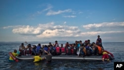 Relawan dari regu penyelamat Barcelona, Spanyol, membantu menurunkan perahu kecil saat para pengungsi turun dari perahu yang membawa mereka dari pantai Turki tiba di pulau Lesbos, Yunani timur laut, Rabu dini hari, 7 Oktober 2015. (Foto: dok).