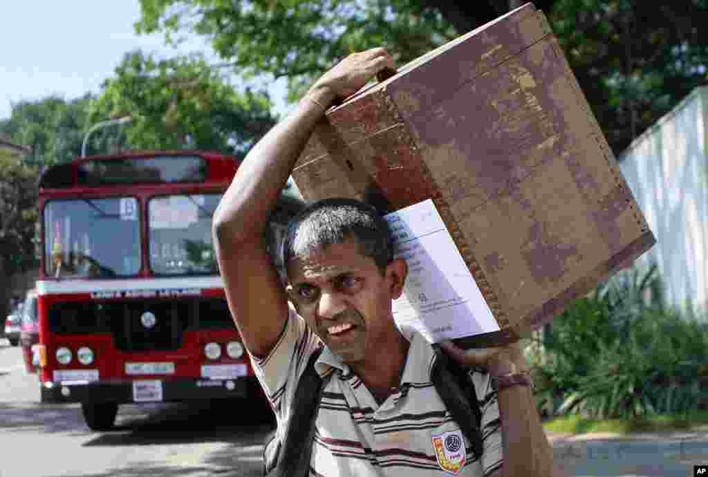 A Sri Lankan polling officer carries a ballot box towards a polling station on the eve of the presidential elections in Colombo, Sri Lanka, Jan. 7, 2015.&nbsp;