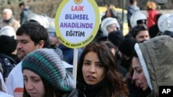 FILE - A woman holds a placard demanding "a secular and science-based education system" as hundreds of students and teachers march in Ankara, Feb. 13, 2015.
