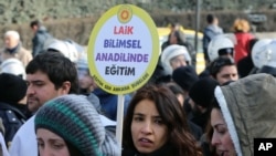 FILE - A woman holds a placard demanding "a secular and science-based education system" as hundreds of students and teachers march at a rally in Ankara, Feb. 13, 2015.