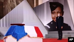 French President Emmanuel Macron pay respect to the cenotaph of Josephine Baker, covered with the French flag, at the Pantheon in Paris, France, Nov. 30, 2021, where she is to symbolically be inducted, becoming the first Black woman to receive France's highest honor. 