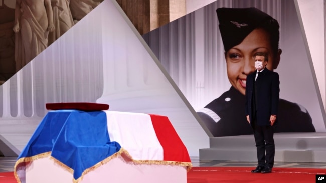 French President Emmanuel Macron pay respect to the cenotaph of Josephine Baker, covered with the French flag, at the Pantheon in Paris, France, Nov. 30, 2021, where she is to symbolically be inducted, becoming the first Black woman to receive France's highest honor.