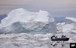 ພາບບັນທຶກເຮືອຫາປາ ກຳລັງລອງໄປຕາມຮ່ອມນໍ້າກ້ອນ ໃກ້ກັບ Ilulissat, Greenland.