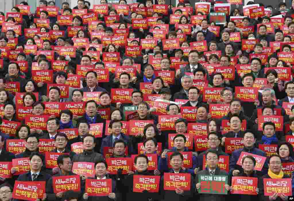 Lawmakers and members of opposition parties hold cards during a rally demanding the impeachment of South Korean President Park Geun-hye at the National Assembly in Seoul.