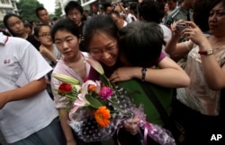 FILE - A Chinese student is greeted by a relative after taking the annual college entrance examinations in Beijing, June 8, 2010.