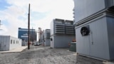 FILE - A group of buildings housing cryptocurrency miners sits in the foreground of a power generating station at the Scrubgrass Plant in Kennerdell, Pennsylvania, U.S., March 8, 2022. Picture taken March 8, 2022. (REUTERS/Alan Freed)