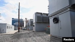 FILE - A group of buildings housing cryptocurrency miners sits in the foreground of a power generating station at the Scrubgrass Plant in Kennerdell, Pennsylvania, U.S., March 8, 2022. Picture taken March 8, 2022. (REUTERS/Alan Freed)