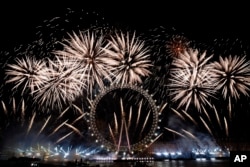 FILE - Kembang api menerangi langit di atas London Eye di pusat kota London untuk merayakan Tahun Baru pada Senin, 1 Januari 2024. (Alberto Pezzali, File/AP)