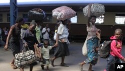 FILE: Women and children carry baggage at the main train station in Harare. (AP Photo/Tsvangirayi Mukwazhi)