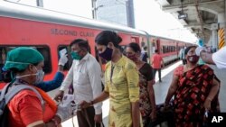 24일 인도 뭄바이 기차역에서 보건 관계자가 탑승객들의 체온을 재고 있다.