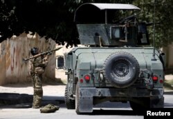 FILE - A member of the Afghan security forces prepares to fire an RPG during a battle with insurgents in Kabul, Afghanistan, Aug. 16, 2018.