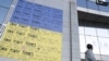 A person walks next to a pro-Ukrainian poster outside the European External Action Service (EEAS) headquarters, in Brussels Belgium, March 5, 2025. 