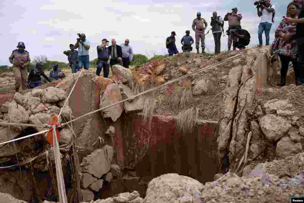 People watch an inspection outside the mine shaft where it is estimated that hundreds of illegal miners are hiding underground, after police cut off food and water as part of police operations against illegal miners, in Stilfontein, South Africa.