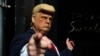 Una persona con una máscara que representa al expresidente de los Estados Unidos Donald Trump hace gestos frente a la Torre Trump en Nueva York, días después de que el republicano asegurara que sería arrestado acusado en un caso de pagos ilegales y pedía a sus seguidores que protestaran, el 22 de marzo de 2023.