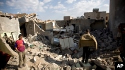 Yemeni boys gather near the rubble of houses destroyed by Saudi airstrikes near Sana'a's airport, March 31, 2015. 