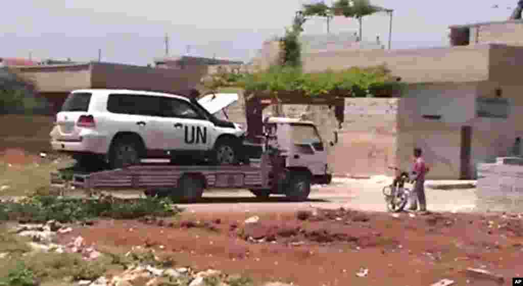 This image made from amateur video shows a towed U.N. observer car in Idlib, Khan Sheikhoun, Syria. (Shaam News Network via AP video)