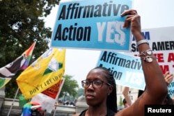 FILE - A woman holds a sign as demonstrators for and against the U.S. Supreme Court decision to strike down race-conscious student admissions programs at Harvard University and the University of North Carolina confront each other, in Washington, U.S., June 29, 2023. (REUTERS/Evelyn Hockstein/File Photo)