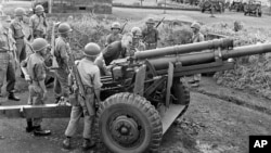 Gen. Maxwell Taylor, President John F. Kennedy's special military adviser, examines a South Vietnamese cannon during a tour of the border between North and South Vietnam, Oct. 22, 1961. 