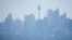 A ferry passes in front of the Central Business District as smoke from bushfires shroud Sydney, Australia, Nov. 11, 2019. 