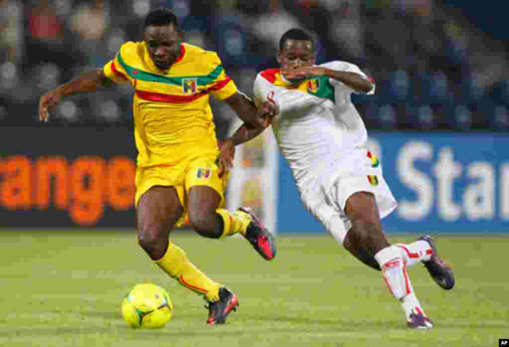 Mali's Tamboura challenges Guinea's Traore during their African Nations Cup Group D soccer match at Franceville Stadium