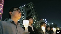 South Koreans take a moment of silence for South Korean marines killed in a North Korean bombardment of a South Korean island, 23 Nov 2010