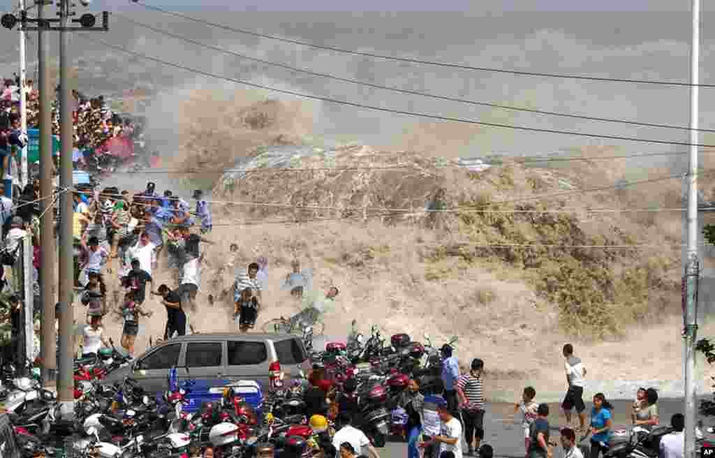 August 31:  Waves created by a tidal bore crash over a barrier on the Qiantang river at Haining, in east China's Zhejiang province.  (AP Photo)