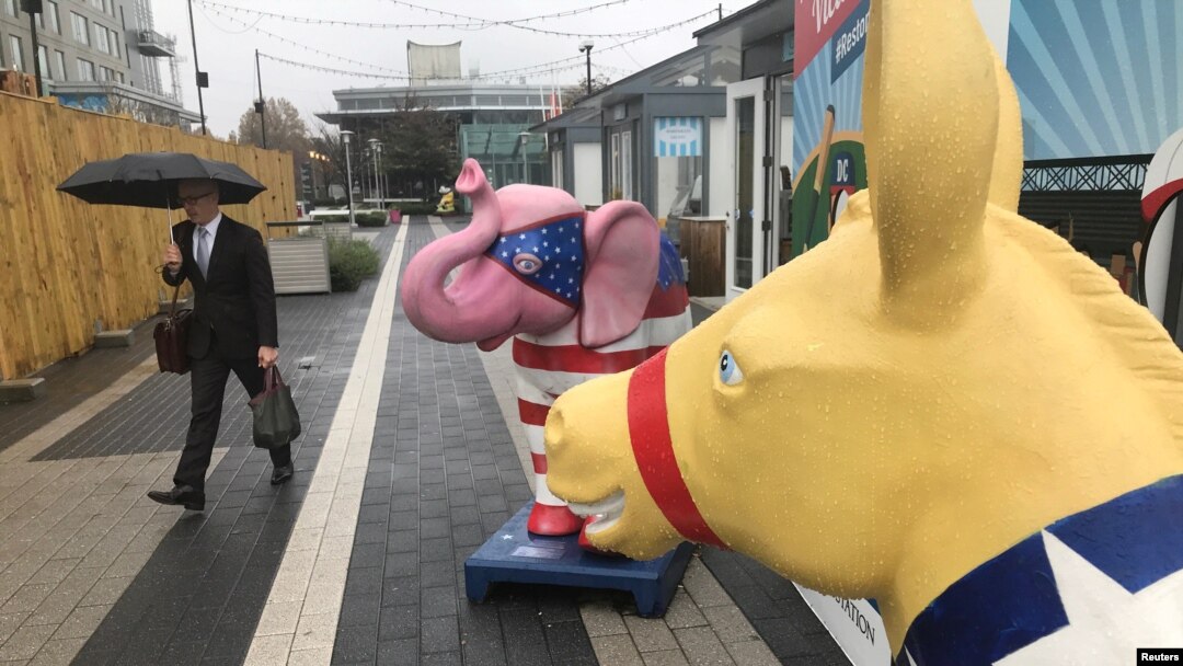 FILE - A commuter walks past a symbolic Republican elephant and Democratic donkey at a metro station in Reston, Virginia, Nov. 5, 2018, one day before U.S. congressional midterm elections.